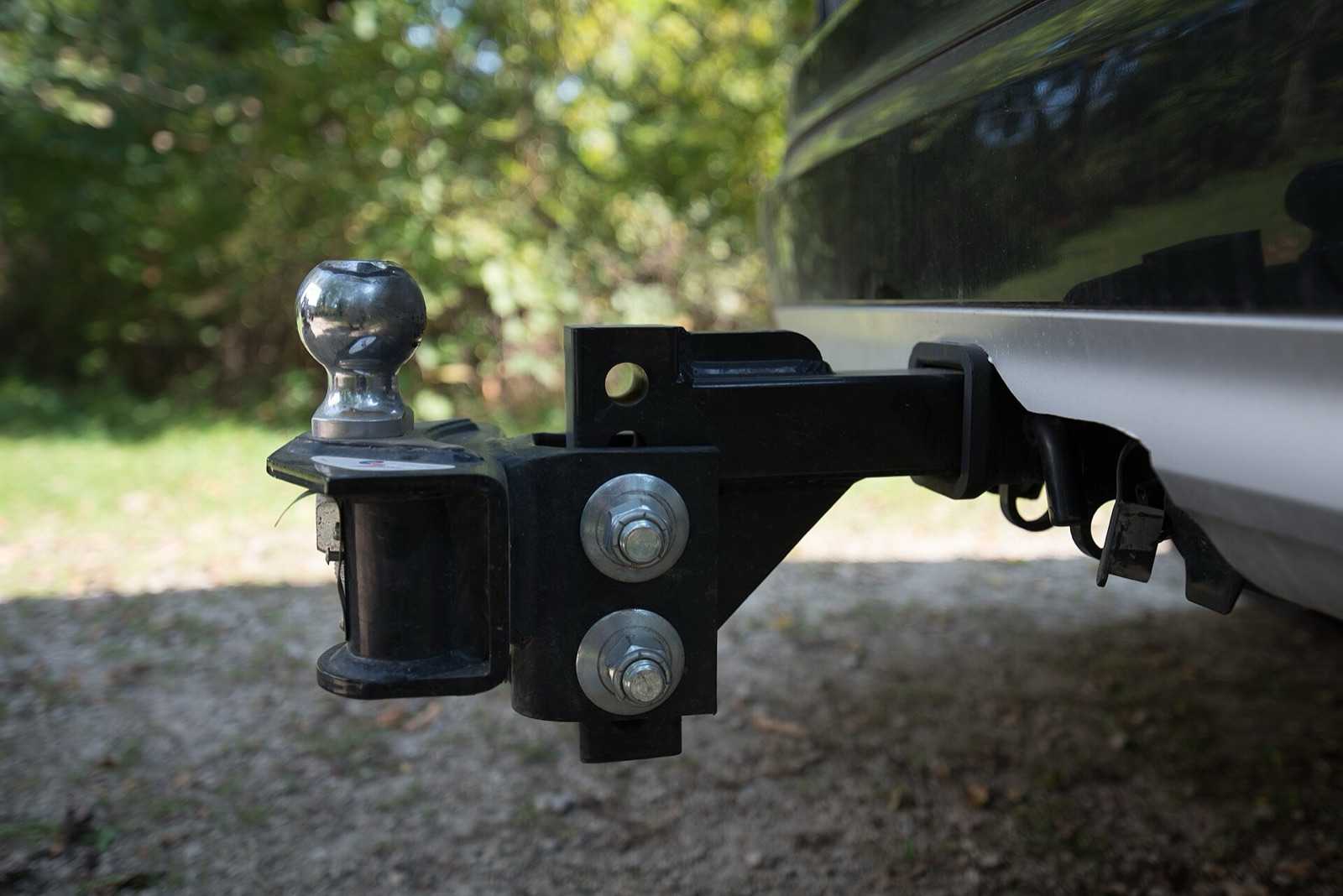Adjustable ball mount on its shank in a truck receiver, with the hitch ball on top and two large bolts on the side